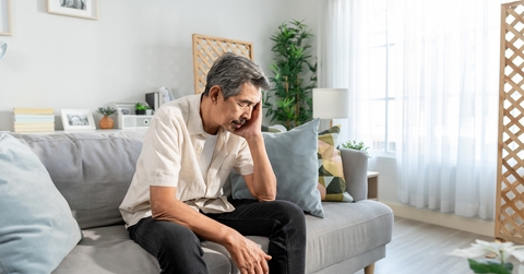 depress man sitting alone in living room at home