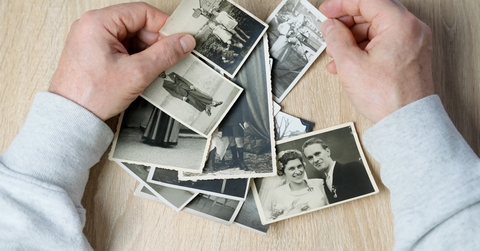 man looks through his old photographs