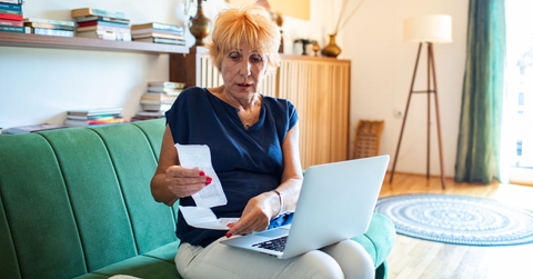 elderly woman reviewing receipts 