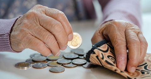 senior woman holding counting coin