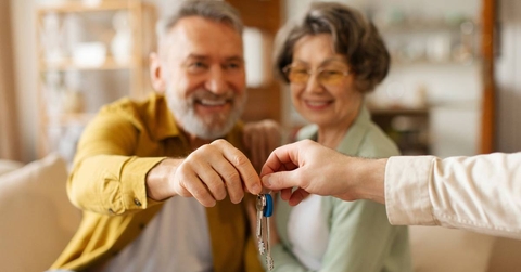 Realtor giving senior couple key to new house