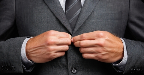 Hands buttoning a suit