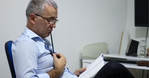 Worried middle-aged businessman having problems at workplace, solving job issues, doing paperwork.