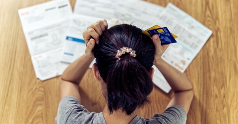stressed woman holding head worry about bills