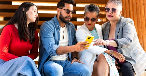 Group of diverse people using smartphone outdoors