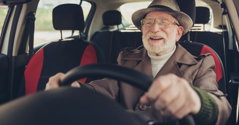 grey-haired man driving car