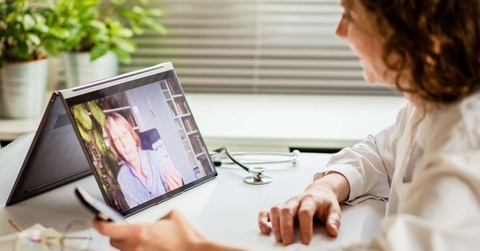woman using laptop and taking her blood pressure