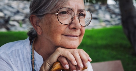 close up of 70 year old woman on sitting on a park bench