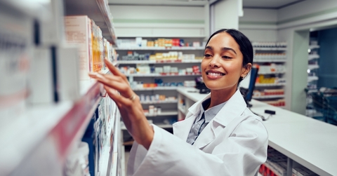 Pharmacist picking medication from shelf