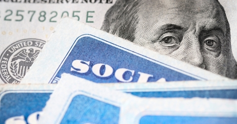 Dollar bill with Benjamin Franklin's eyes looking and Social Security cards