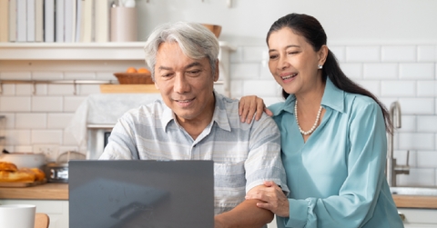 senior asian couple collaborate on a laptop