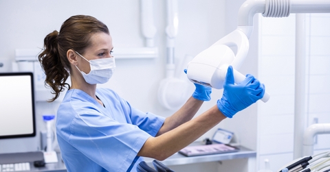 dental assistant adjusting light 