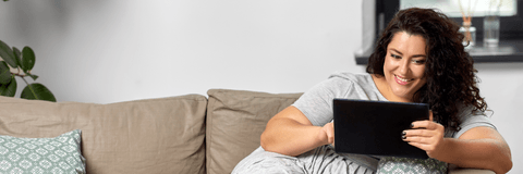 person on couch using tablet device