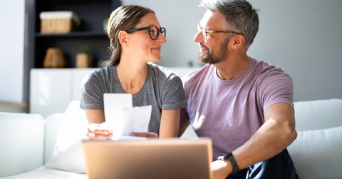 Happy couple looking at each doing paperwork