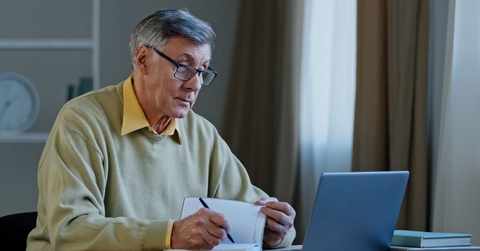 Mature man with laptop and notebook