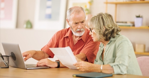 Concerned retired couple on laptop