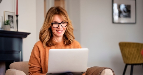 Woman sitting in living room on laptop