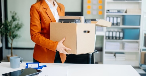 Business woman holding box with desk belongings