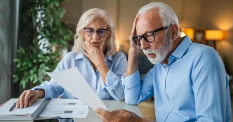 Older couple looking shocked when doing paperwork