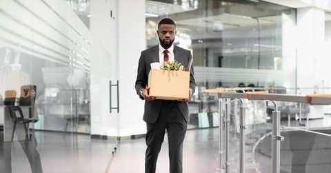 Fired male employee with box of belongings