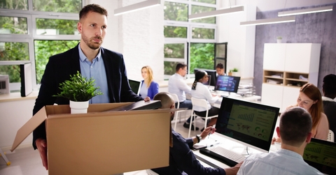Man fired and holding box walking out of the office