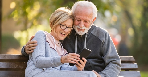 Happy retired couple on park bench